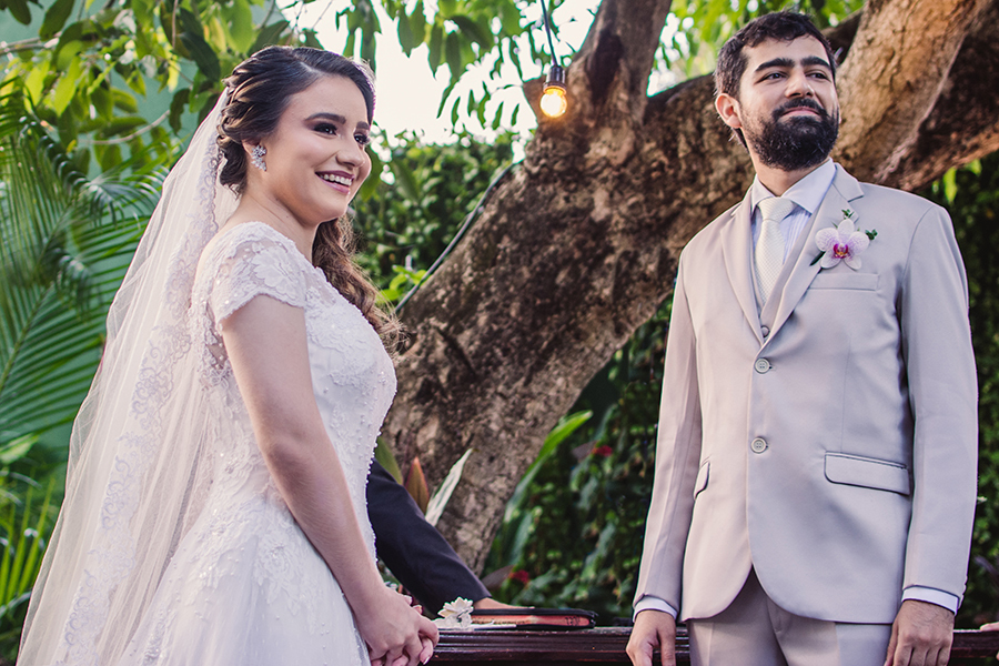 noivos sorrindo com entrada das alianças no casamento no Pipo restaurante em Fortaleza