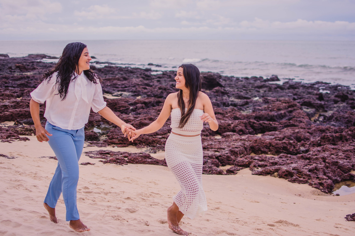 Casal gay correndo na praia de iracema em seu ensaio de casal de lesbicas na pria de iracema na cidade de Fortlaeza