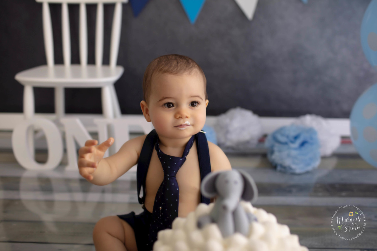 Fotografia de criança de 12 meses sentado comendo um delicioso bolo em seu ensaio Smash The Cake no studio na Vila Madalena São Paulo SP