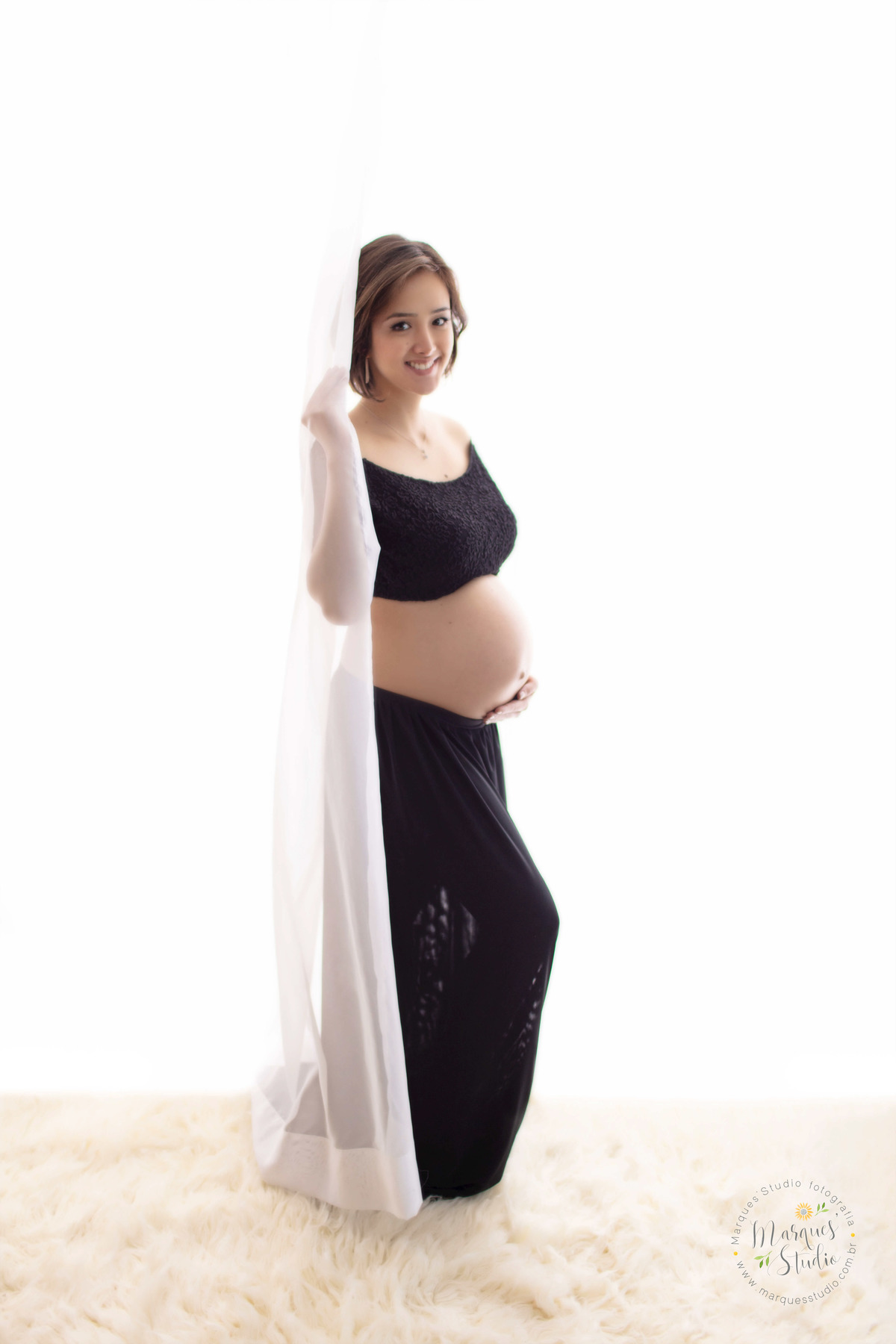 Foto feita para o lindo ensaio de gestante da Thais no studio localizado na zona Oeste de São Paulo Capital Vila Leopoldina ela está no fundo branco usando um belo conjunto de top e saia preto ela está com 35 semanas de gestação
