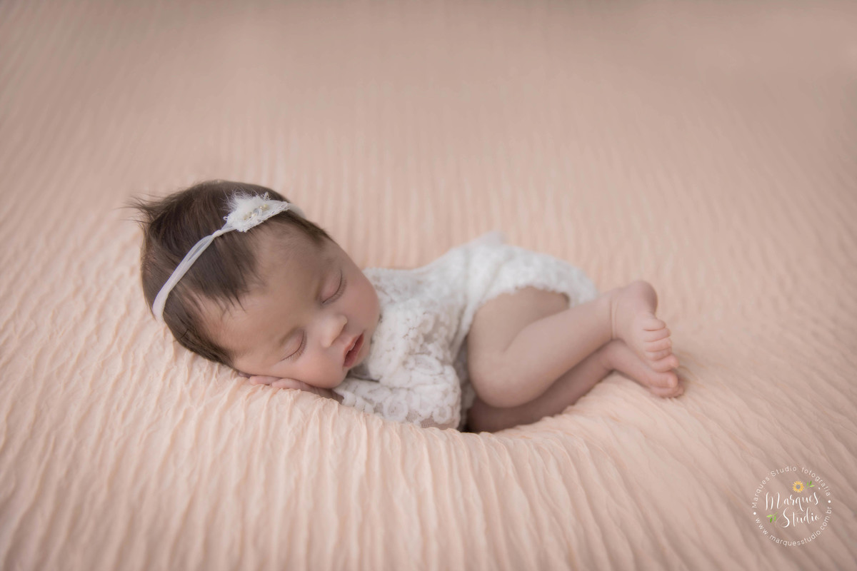 Foto recém-nascido menina usando roupinha na cor bege com renda no puff, feita em estudio fotográfico em Osasco, São Paulo, SP, ela usa uma linda headband na cor bege com pérolas