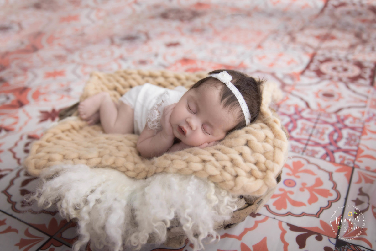 Fotografia de bebê em cesto, com roupa bege e em fundo de azulejo. Foto feita em Estúdio na zona sul São Paulo - SP, para o newborn da Clara