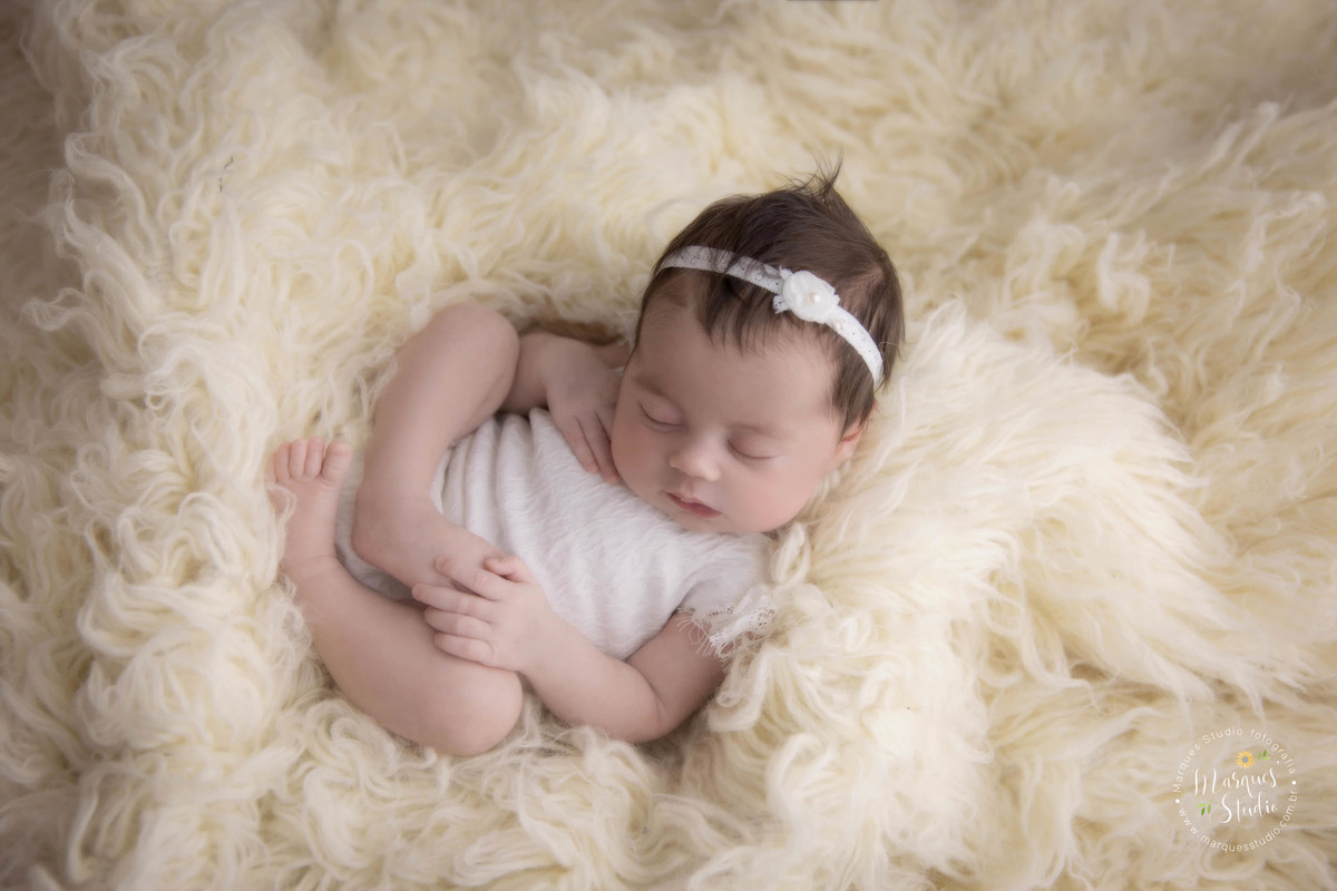 Foto de recém-nascido, usando roupinha bege com lacinho no cabelo bege, no studio localizado na zona Sul de São Paulo, SP, Morumbi.