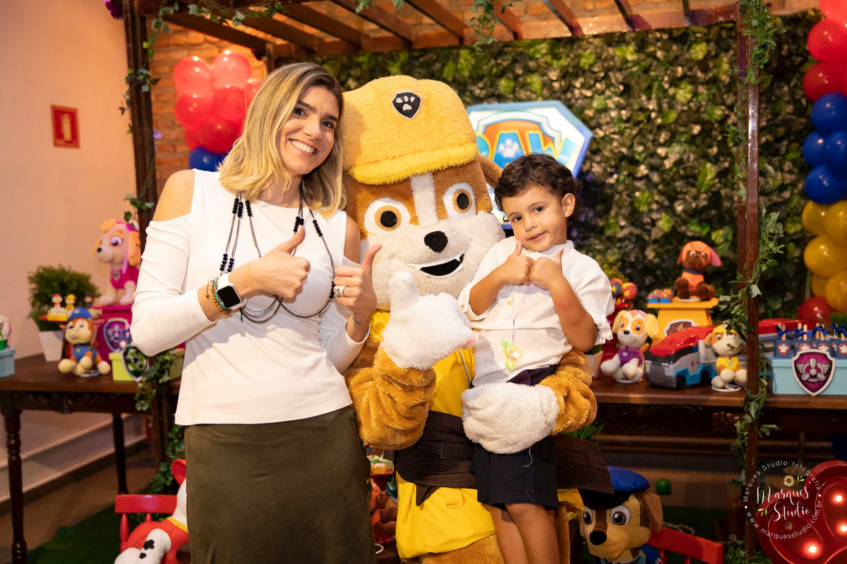 Foto feita no aniversário do Joaquim de 4 anos, na foto o aniversariante está com a sua tia e o animador vestido como personagem da patrulha canina, eles estão sorridentes e felizes. Buffet que fica na Zona Oeste de São Paulo, SP