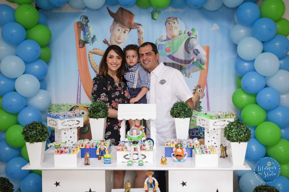 Fotografia de um lindo aniversário, na foto temos o Guilherme e seus pais, uma linda mesa decorada com o tema Toy Story, com muitos docinhos, balões coloridos, brinquedos dos personagens do filme Toy Story, o buffet fica na Pompeia, São Paulo, SP.