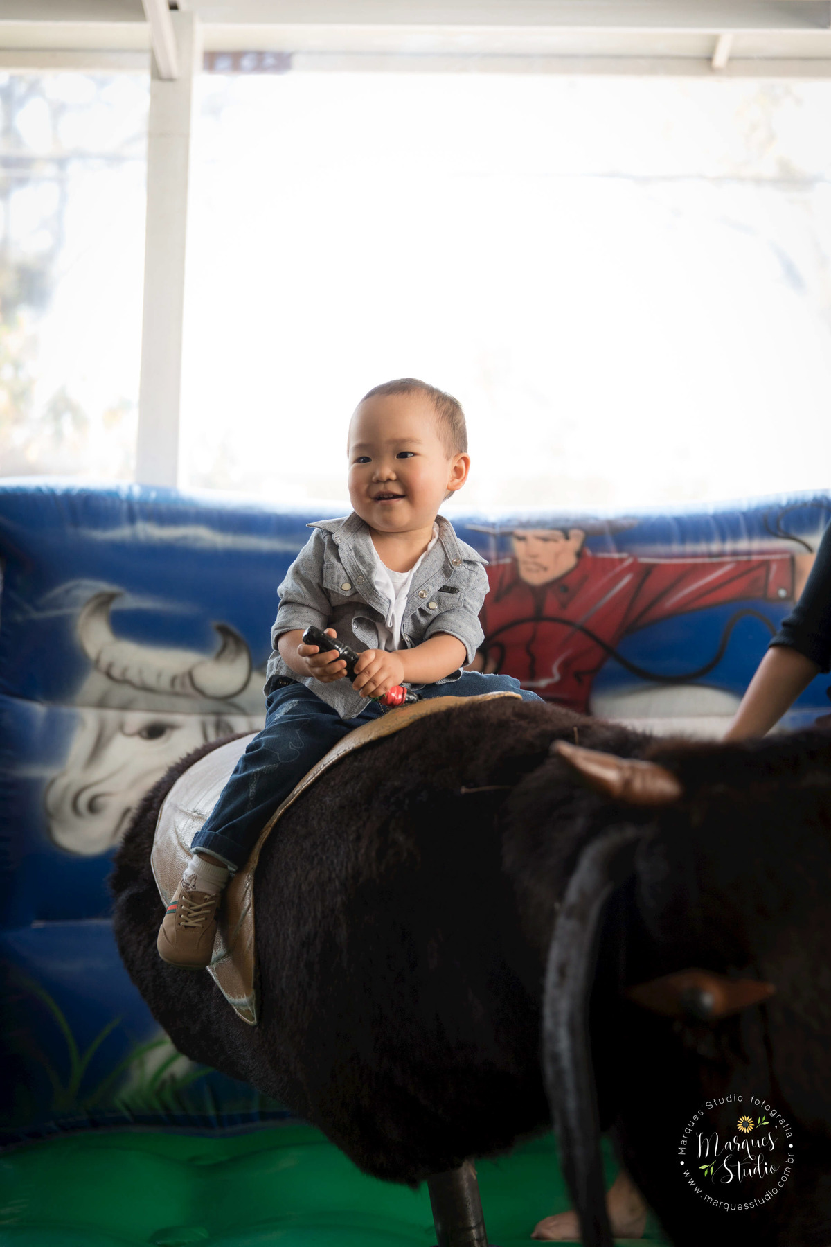 Foto tirada no aniversário do Rafael de 2 aninhos no Buffet que está localizado na Av. Paulista- São Paulo. Na foto temos o aniversariante brincando em um touro mecânico.
