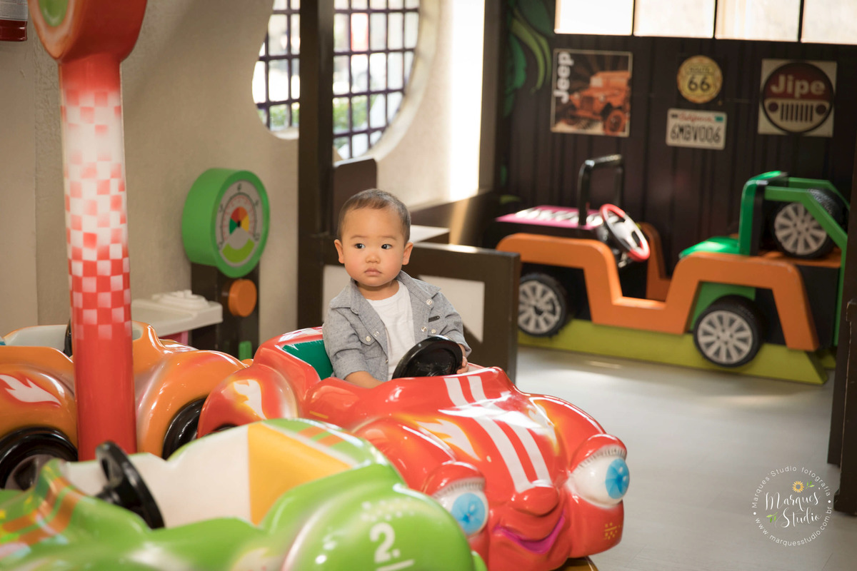 Foto tirada no aniversário do Rafael de 2 aninhos no Buffet que está localizado na Zona sul de São Paulo. Na foto temos o aniversariante brincando em um lindo carrinho vermelho. 