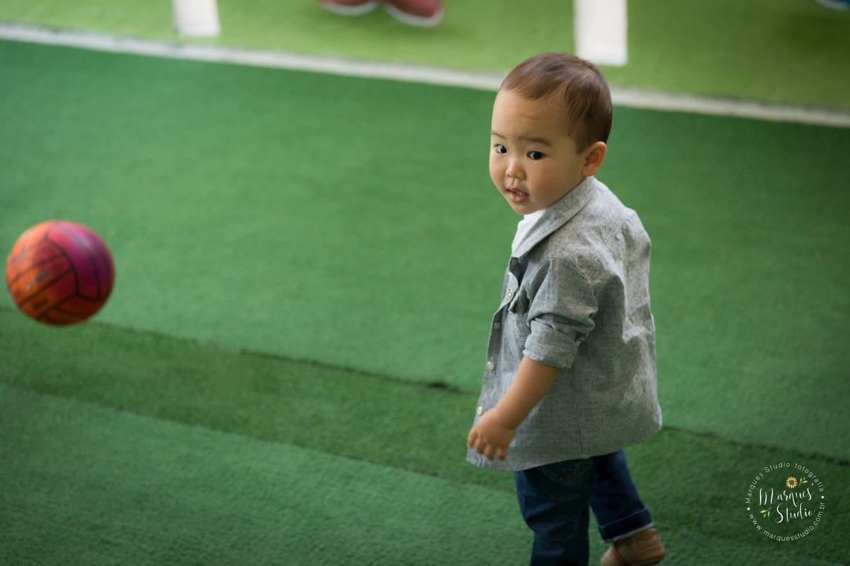 Fotografia feita no aniversário de dois anos do Rafael, em um buffet localizado em Sumaré - São Paulo, SP. Na foto temos o aniversariante brincando de bola em um campinho de futebol.