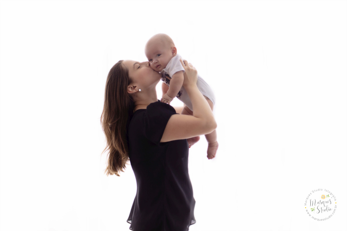 Fotografia feita no ensaio fotografico de 03 meses do Enrico. Na foto a mamãe está carregando o bebê pra cima e lhe dando um beijo. Studio encontra-se localizado em Santo Amaro - São Paulo, SP.