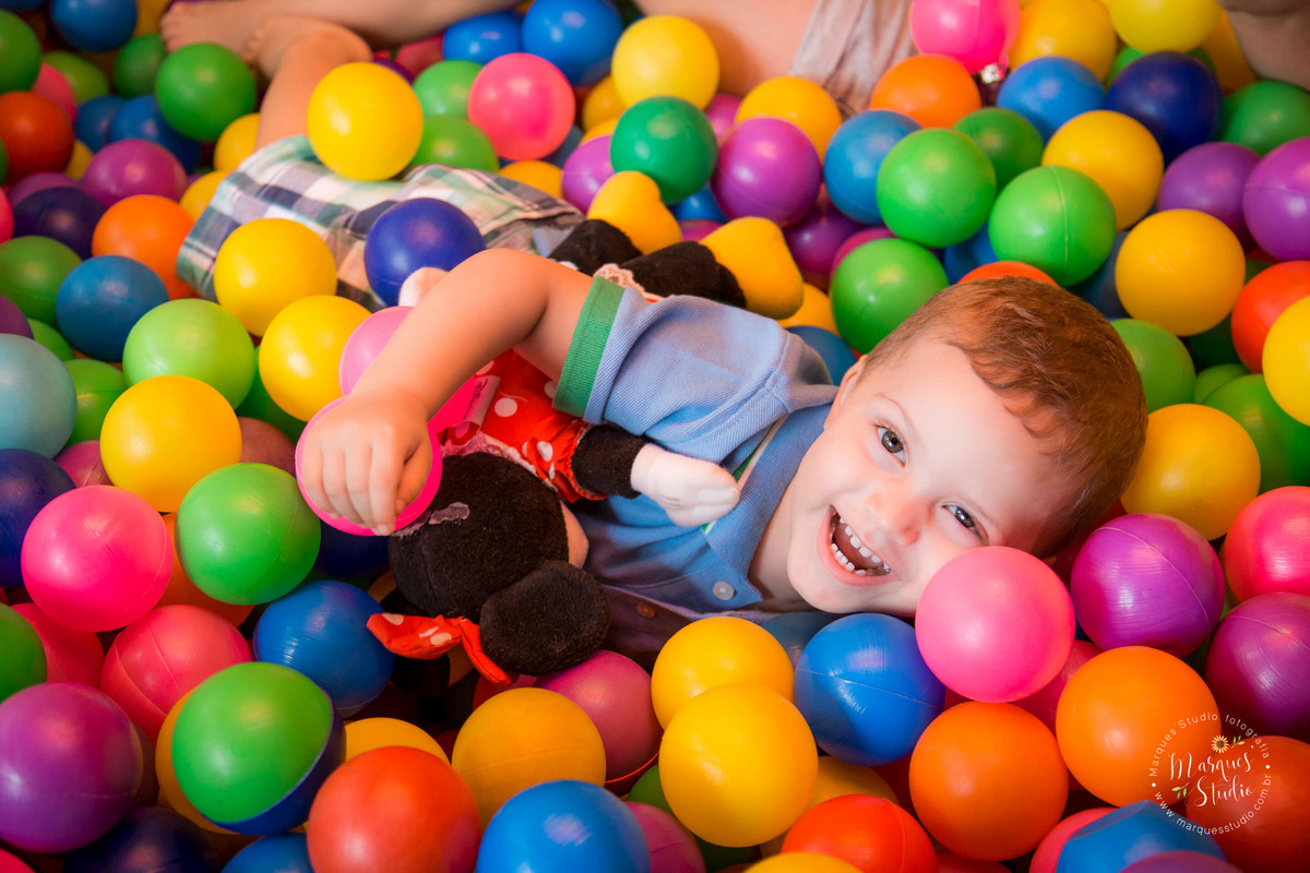 Fotografia registrada na festa de aniversário do Guilherme que estava fazendo 2 aninhos. Na foto o aniversariante está se divertindo muito em uma piscina de bolinhas coloridas. A foto foi tirada em um buffet localizado na Zona Oeste de São Paulo.