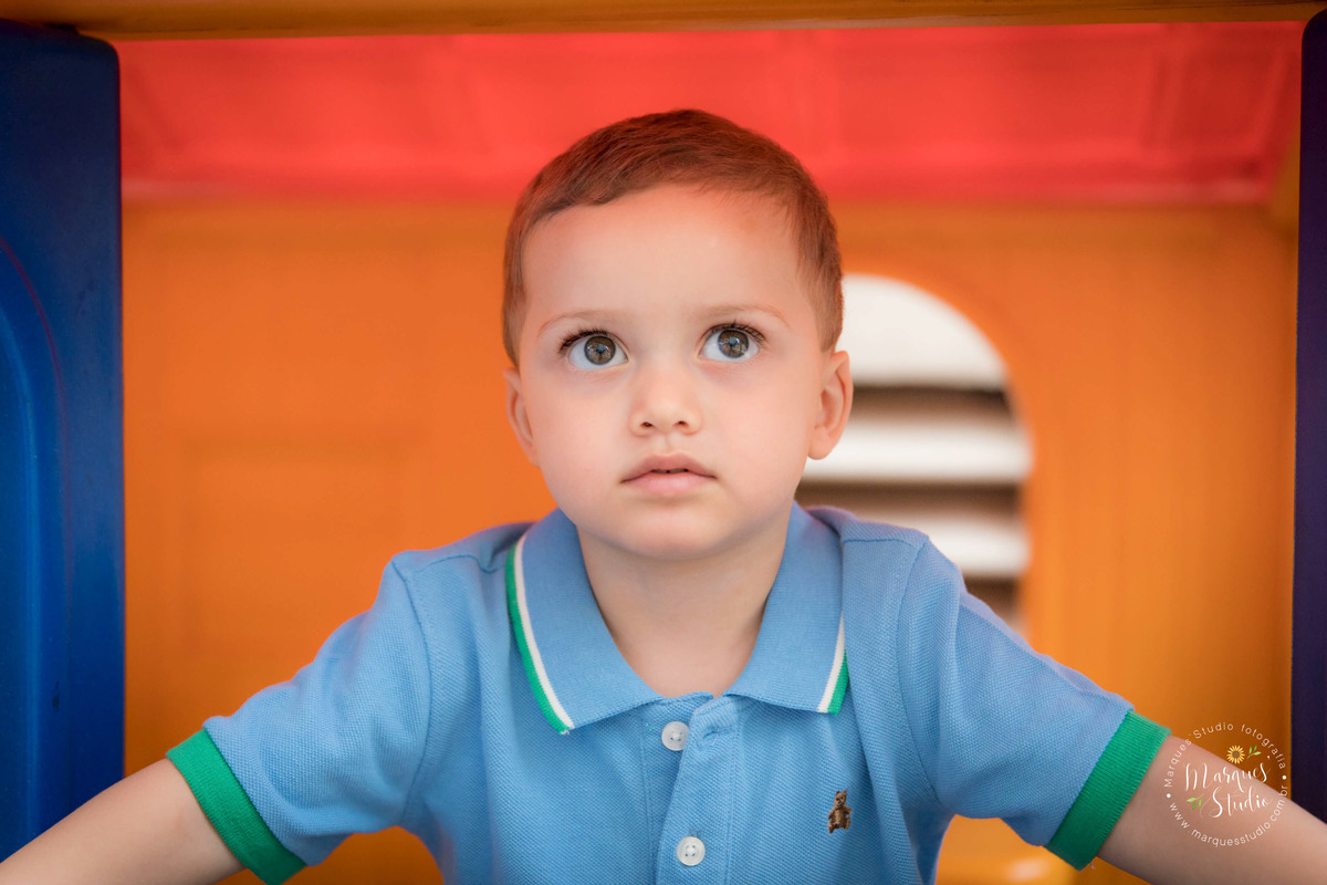 Foto tirada na festinha de aniversário do Guilherme. Na foto temos um close do rosto do Gui dentro de um brinquedo colorido. O buffet na da festa está localizado na Vila Madalena - São Paulo, SP
