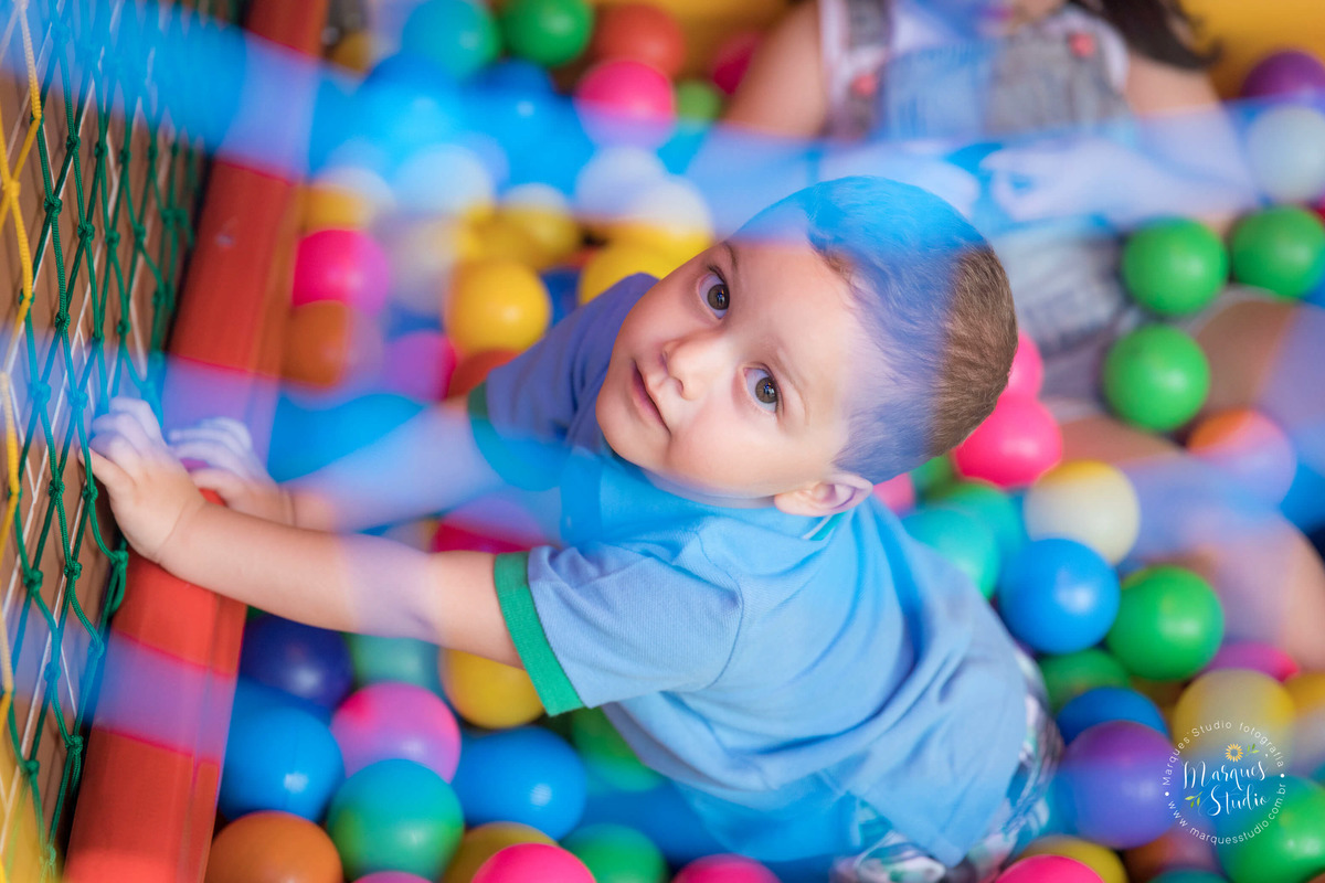 Foto tirada na festinha de aniversário do Guilherme. Na foto temos um close do rosto do Gui dentro de uma piscina de bolinhas coloridas. O buffet na da festa está localizado na Av. Consolação - São Paulo, SP
