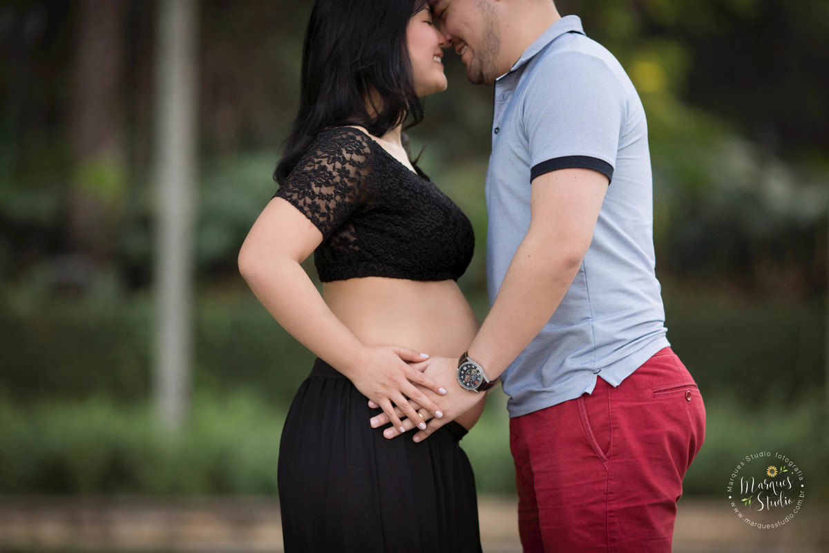 Ensaio fotografico de gestante da Karla. Na foto temos a mamãe e o papai segurando a barriga e com os narizes encostados, sorrindo apaixonados. A foto foi tirada na Zona Oeste de São Paulo - SP. 