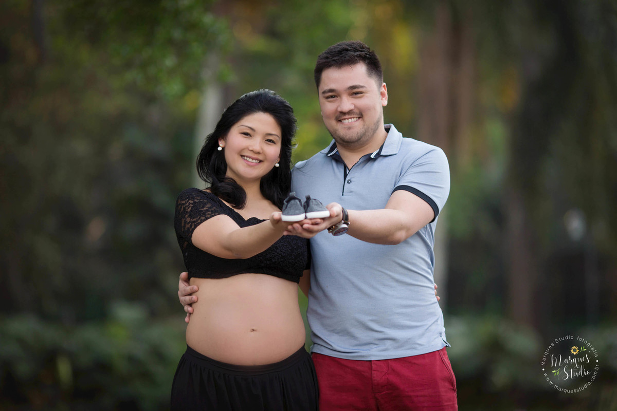 Fotografia registrada em Osasco - São Paulo - SP, no ensaio de gestante da Karla. Na foto temos o papai abraçando a mamãe e juntos estão segurando o sapatinho do seu bebê. O fundo fotográfico é um lindo jardim. A foto foi tirada em Sumaré - São Paulo, SP