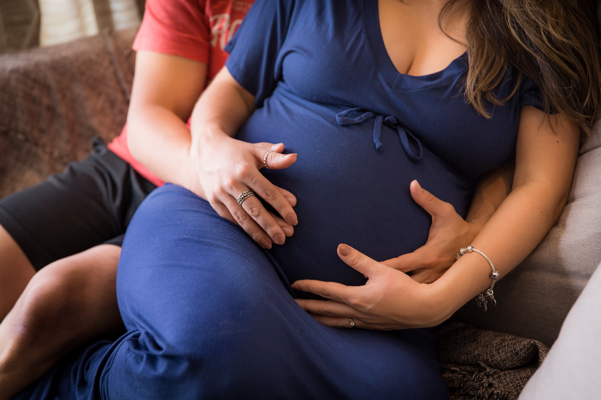 pais abraçando a barriga do futuro filho