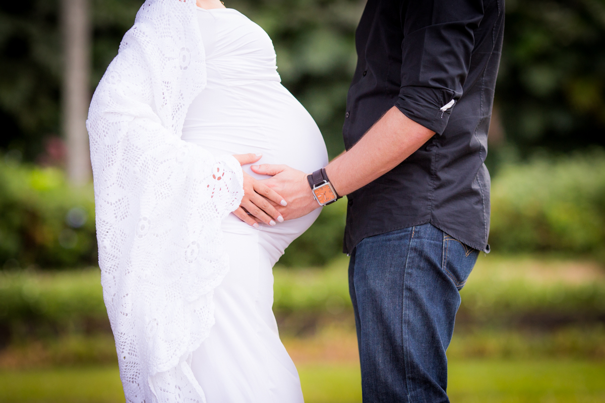 gestante e seu esposo segurando sua barriga admirando sua futura filha. ensaio externo realizado em São Paulo