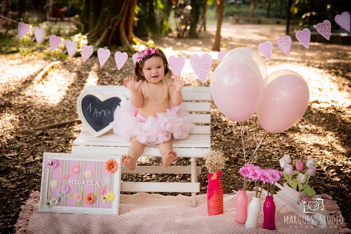 menina sentada no banquinho branco com bexigas