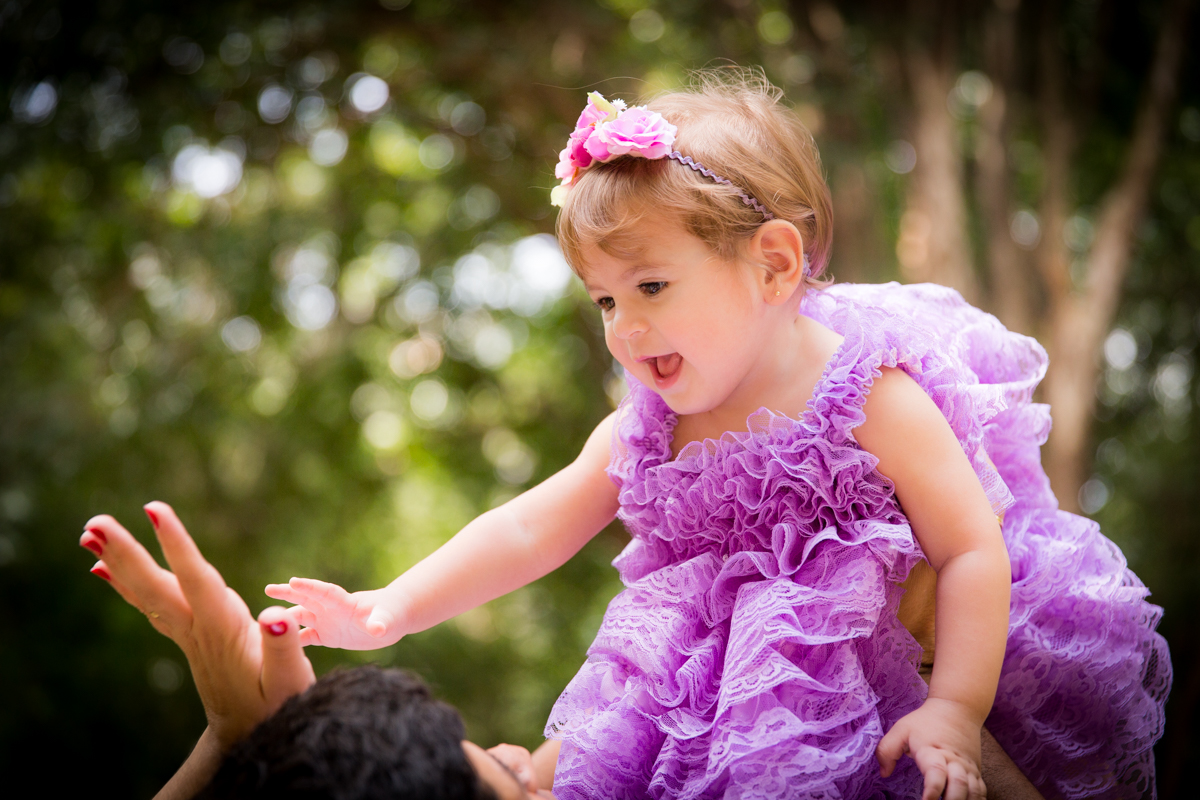 bebe de 1 ano sorrindo em ensaio fotográfico em parque