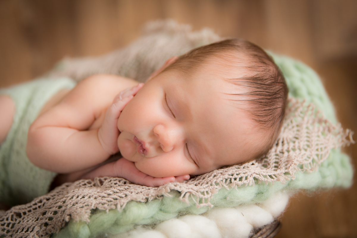 fotografia de bebê com as mãozinhas no rosto feita em studio
