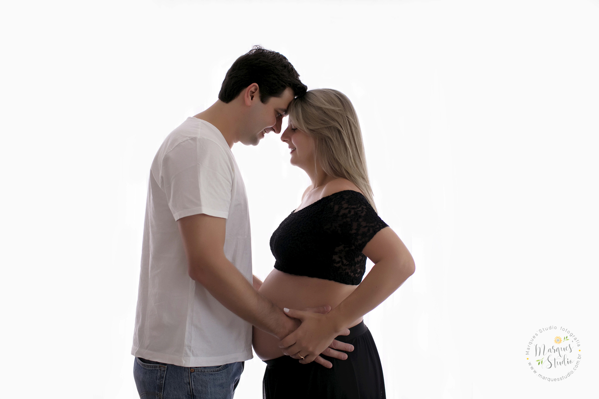 Fotografia feita no ensaio de gestante da Graziella de 31 semanas. Na foto o papai segura a barriga da mamãe, enquanto eles se olham com as testas encostadas, eles se olham de forma apaixonada. Studio está localizado em Osasco - São Paulo, SP.
