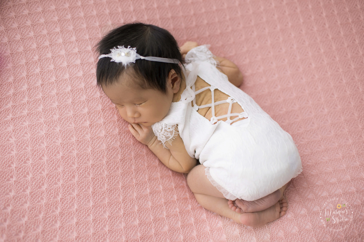 Newborn da Beatriz de 15 dias realizado em studio localizado na Vila Leopoldina - São Paulo, SP. Na foto a bebê está deitada em um puff rosa usando uma roupinha branca. 