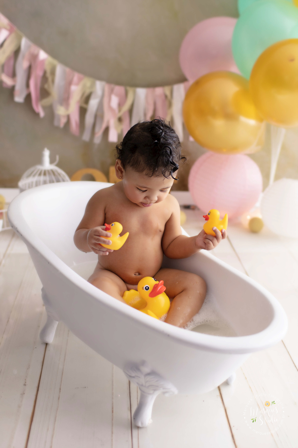 Foto feita em studio localizado em Jardins - São Paulo, SP, na foto temos a Marina no seu smash the cake, dentro de uma banheira cheia de espuma e muitos patinhos, ela está brincando na água.