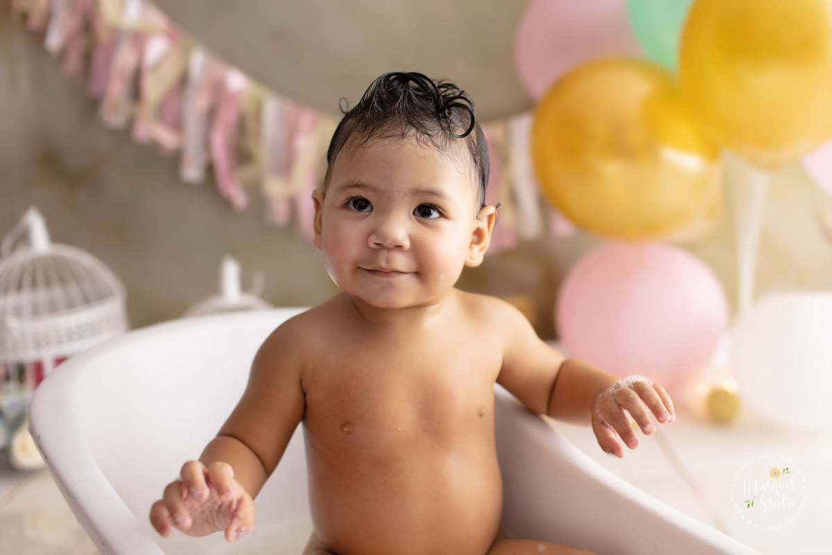 Foto feita em studio localizado no Bela Vista - São Paulo, SP, na foto temos a Marina no seu smash the cake, dentro de uma banheira cheia de espuma e muitos patinhos, ela está brincando na água, a foto é num close no seu rosto sorridente