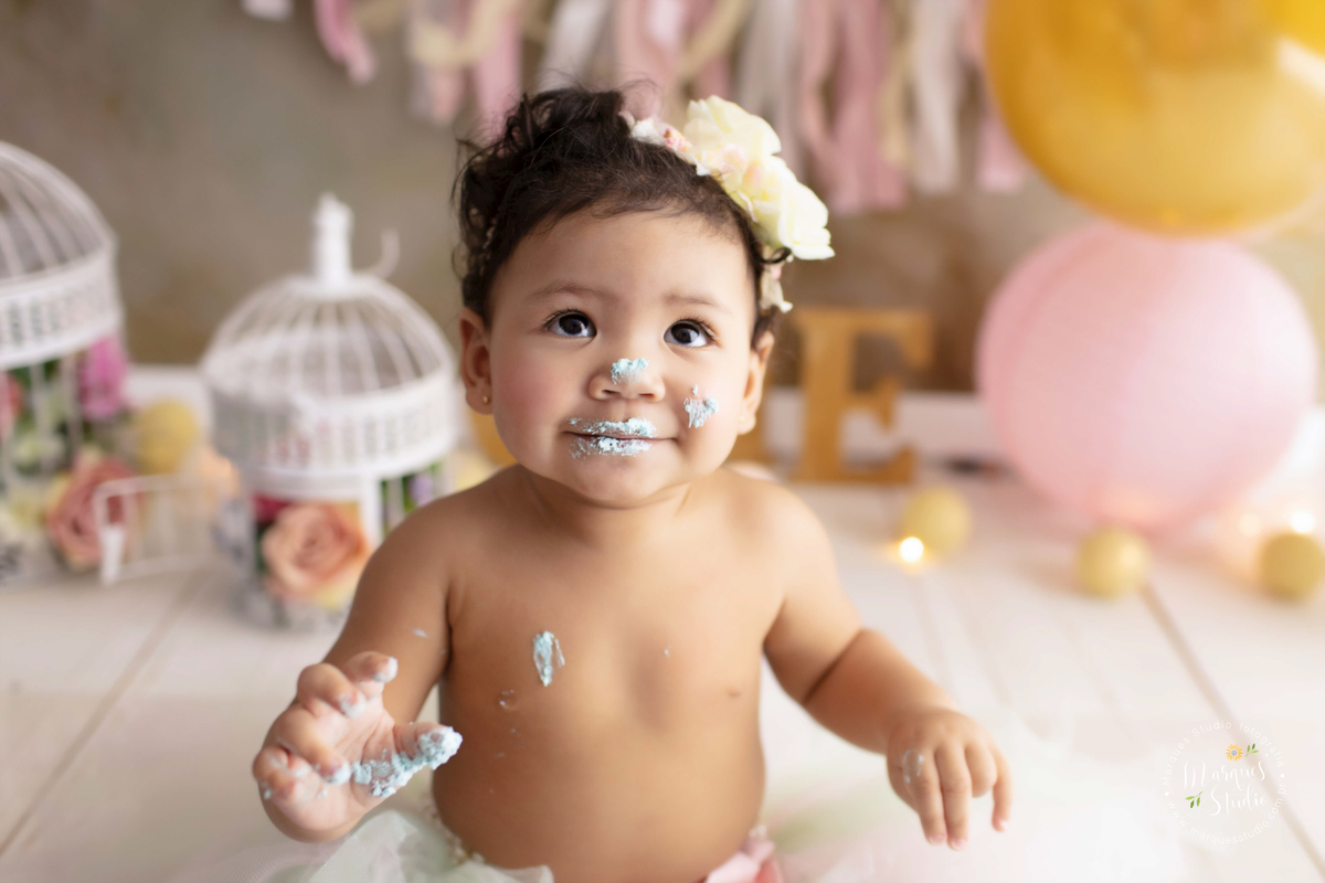 Studio localizado no Morumbi - São Paulo, SP, na foto temos a Marina no seu smash the cake. Um close do rosto do bebê que está com as mãos e o nariz sujo de bolo, sorrindo e se divertindo com sua sujeira.