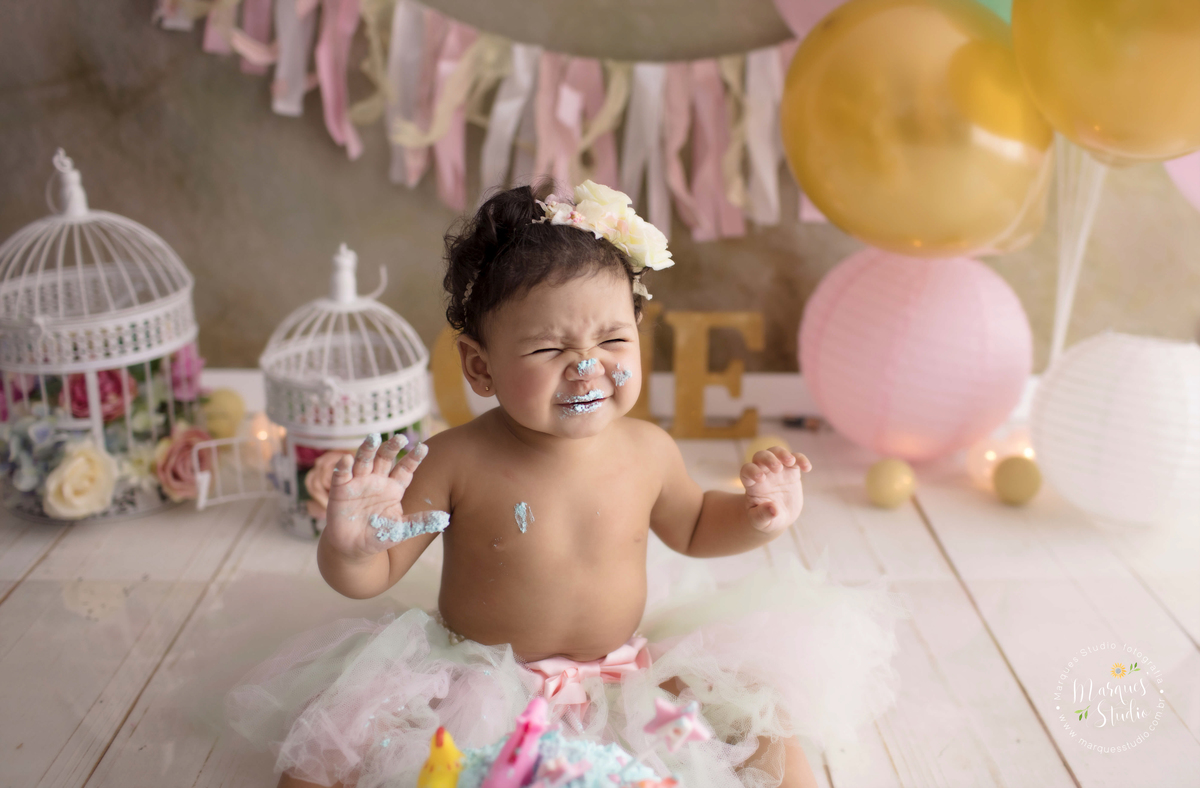 Ensaio feito em studio localizado na Pompeia - São Paulo, SP, na foto temos a Marina no seu smash the cake. Um close do rosto do bebê que está com as mãos e o nariz sujo de bolo, sorrindo e se divertindo com sua sujeira.