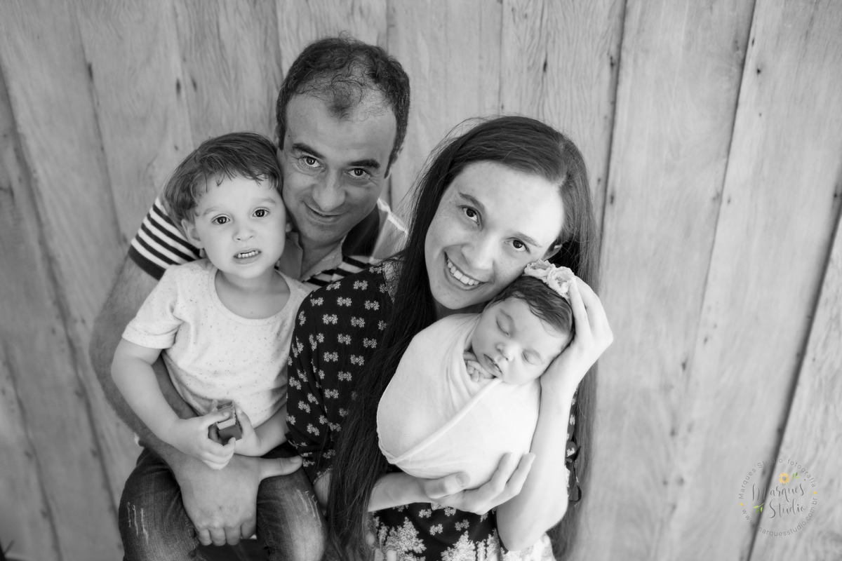Foto feita para ensaio newborn em studio localizado em Santa Cecília - São Paulo, SP. Na foto a bebê está no colo da sua mamãe enquanto o papai segura o seu irmão mais velho. 