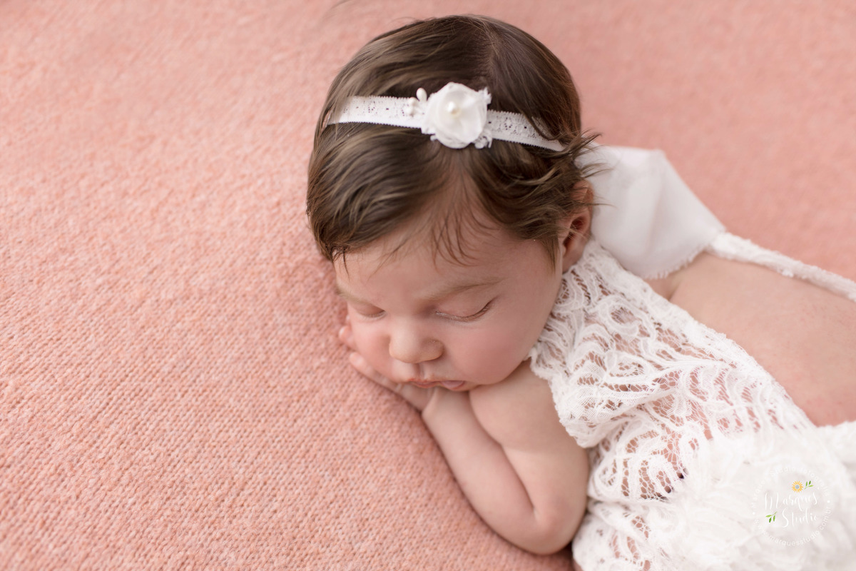 Newborn da Isabel de 16 dias realizado em studio localizado na Vila Leopoldina - São Paulo, SP. Na foto a bebê está deitada em um puff rosa com as mãos em baixo do rosto, a foto foi tirada de cima para baixo.