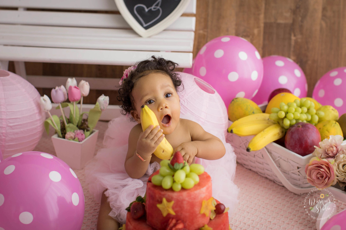 Ensaio smash the fruit feito em studio que encontra-se localizado o Jardins - São Paulo, SP. Na foto a bebê Tayala está rindo e mostrando para todos a banana amarela que ela está segurando