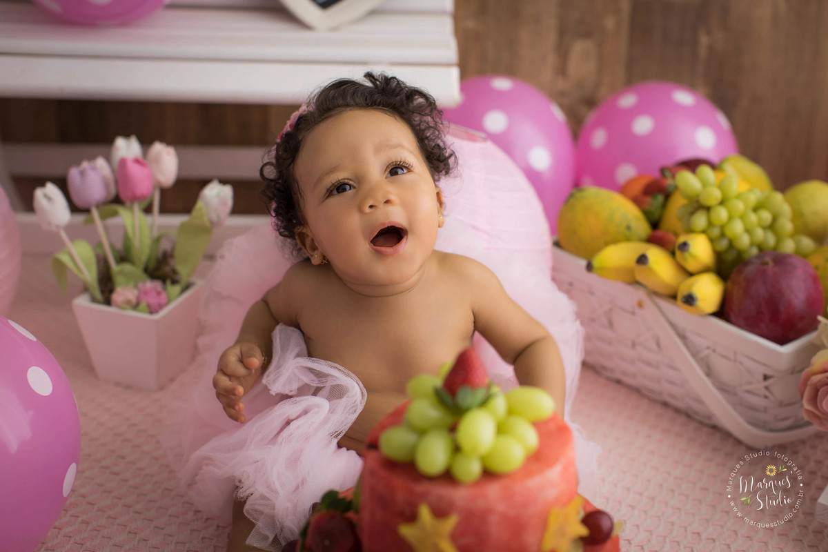 Ensaio smash the fruit feito em studio que encontra-se localizado em Osasco - São Paulo, SP. Na foto a bebê Tayala está rindo bem de frente para o seu lindo bolo