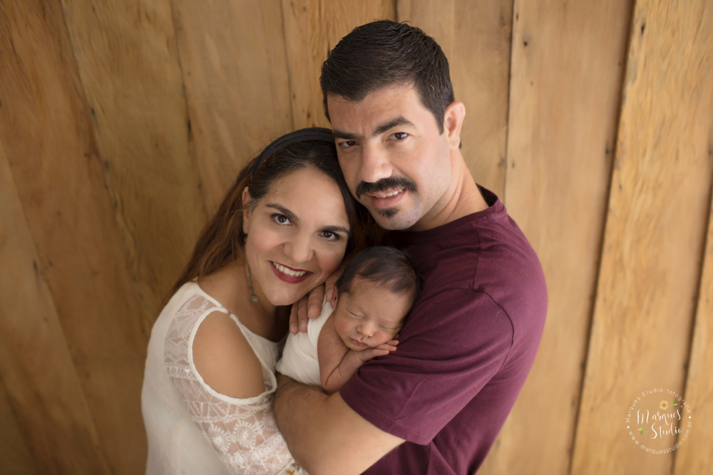 Fotografia em família feita no ensaio newborn do Pietro. Na foto o papai está segurando o Pietro enquanto a mamãe abraça os dois. o studio localiza-se na Pompeia - São Paulo, SP. 