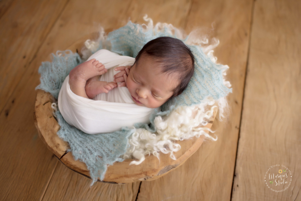 Foto feita para ensaio newborn do Pietro de 12 dias, em studio localizado na Av. Brigadeiro - São Paulo, SP. Na foto o bebê está deitado em uma madeira enrolado em um wrep bege, o fundo fotográfico é de madeira 