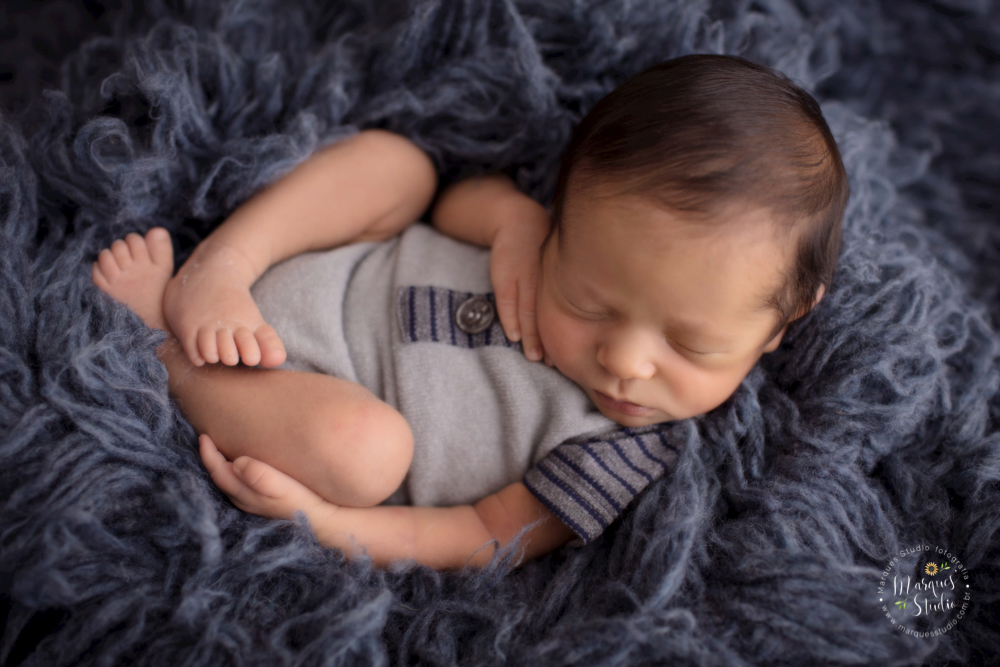 Foto feita para ensaio newborn do Pietro de 12 dias, em studio localizado no Morumbi - São Paulo, SP. Na foto o bebê está deitado em um tapete azul escuro usando uma roupinha azul.