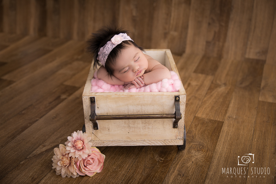 Luiza em seu book Newborn no vagão com roupinha rosa e detalhe de flores