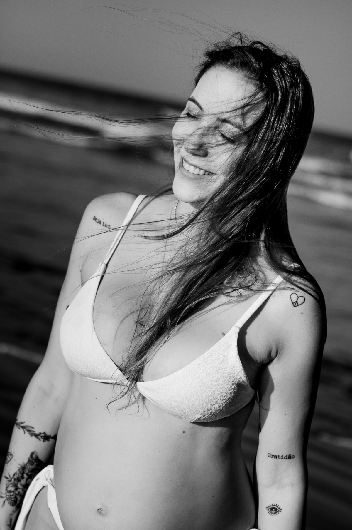 fotografia de gestante - fotografia de gestante na praia por do sol -  fotografia espontânea - fotografia afetiva - preto e branco - tatuagem