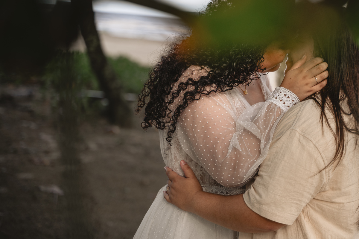 Ensaio de pré casamento na praia , casal prestes a beijar emoldurados pela natureza