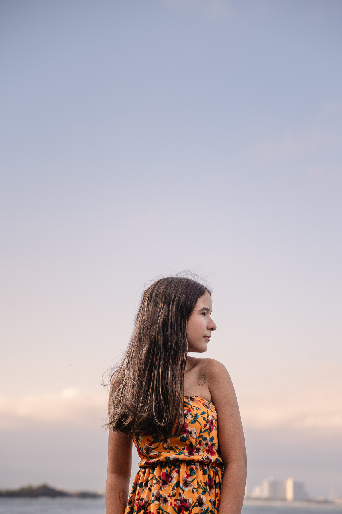 fotografia de debutante - 15 anos - ensaio de 15 anos - ensaio de debutante - ensaio na praia - ensaio no por do sol - mar - céu azul - gaivota