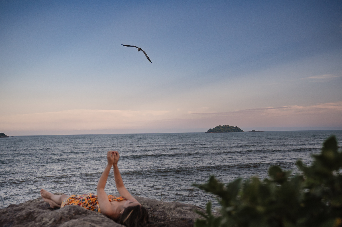 fotografia de debutante - 15 anos - ensaio de 15 anos - ensaio de debutante - ensaio na praia - ensaio no por do sol - mar - céu azul - gaivota - 