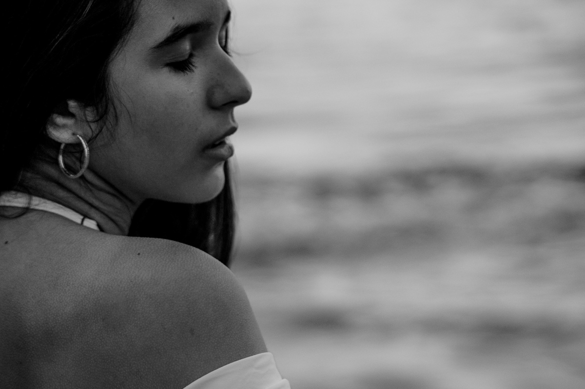 fotografia de debutante - 15 anos - ensaio de 15 anos - ensaio de debutante - ensaio na praia - ensaio no por do sol - mar - céu azul - gaivota - foto em preto e branco
