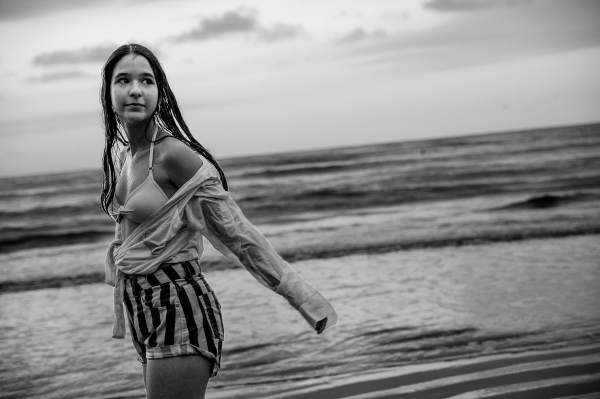 fotografia de debutante - 15 anos - ensaio de 15 anos - ensaio de debutante - ensaio na praia - ensaio no por do sol - mar - céu azul - gaivota - foto em preto e branco