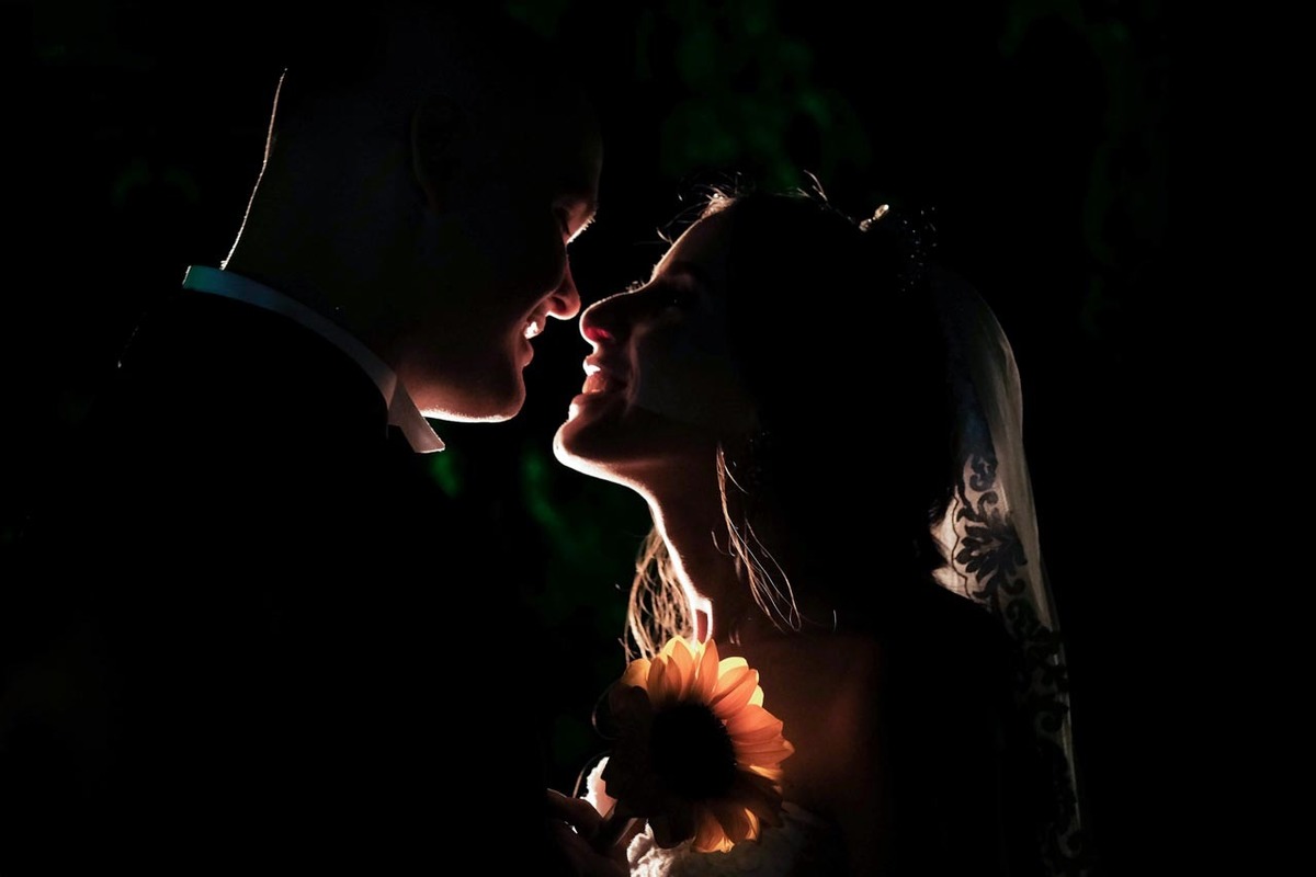 beijo do casal com linda luz e girassol no ensaio com casal em cerimônia de casamento em Guaratinguetá foto erasmo ballot