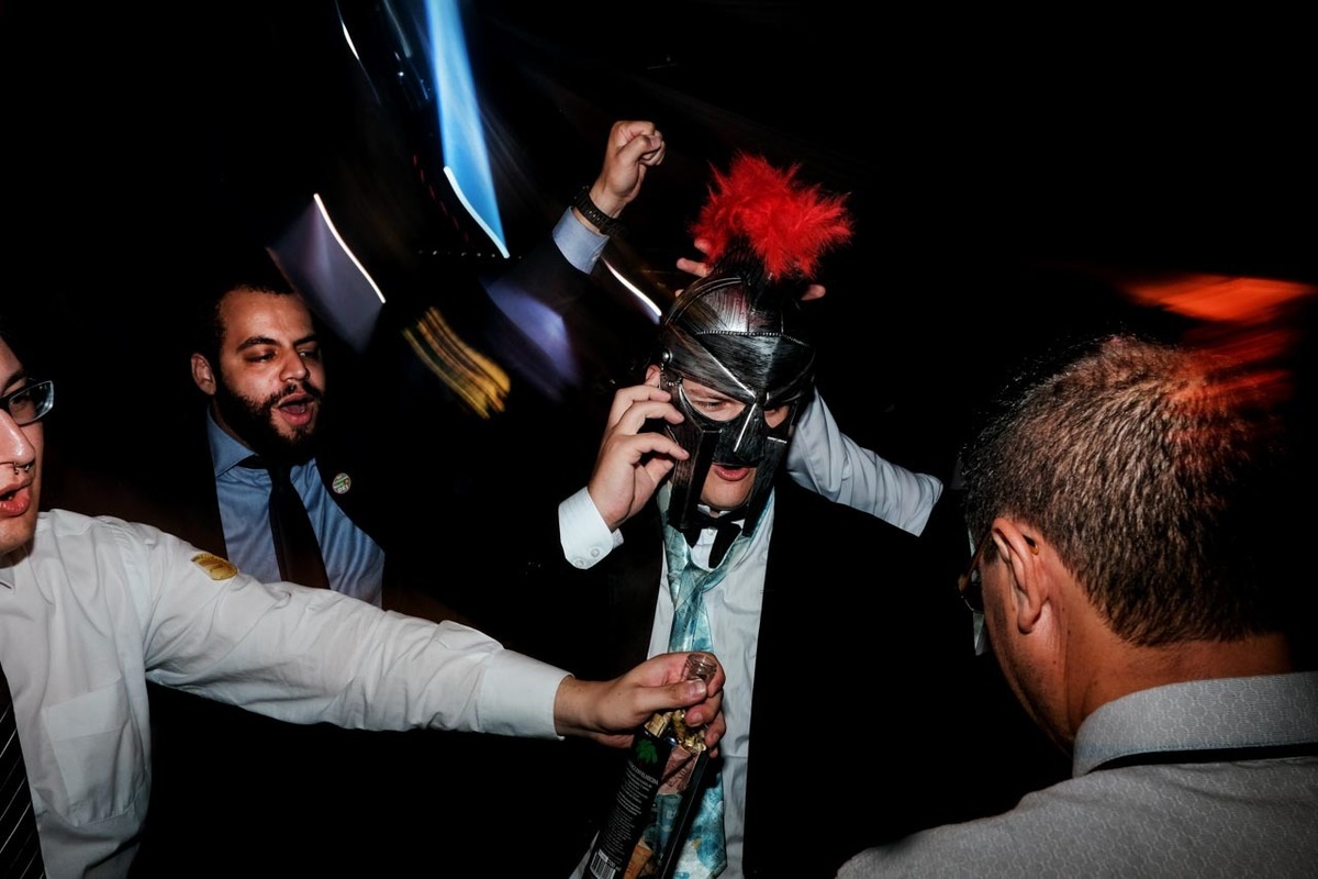 noivo com capacete mascara no momento descontraído da gravata no recanto vip em Guaratinguetá em festa de casamento foto erasmo ballot