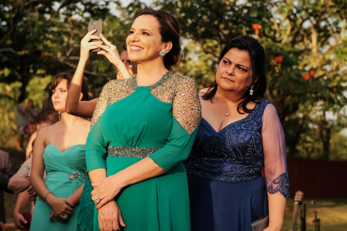 click do fotografo flagra a mãe da noiva ansiosa com a entrada da  filha em casamento lindo no pôr do sol no hotel fazenda sete lagos em Guaratinguetá fotos erasmo ballot
