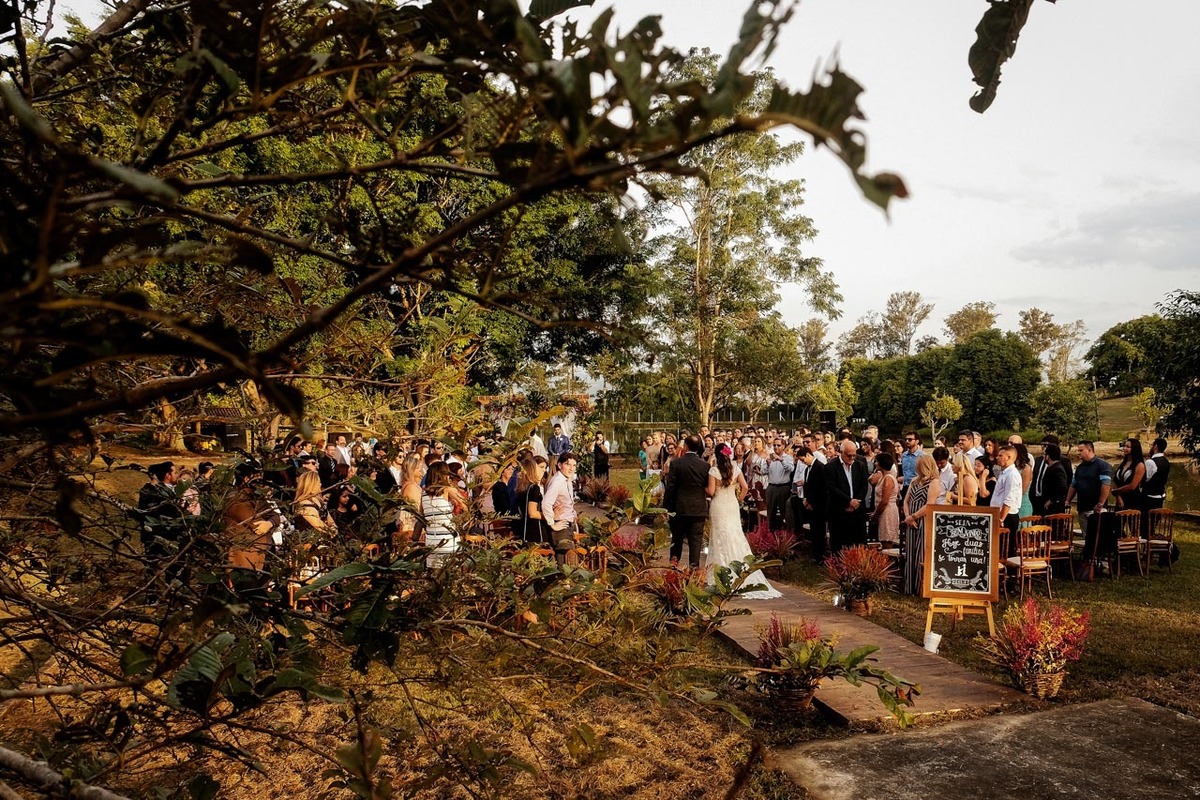 uma visão da entrada da noiva de forma criativa com um olhar  diferenciado do fotografo em casamento lindo no pôr do sol no hotel fazenda sete lagos em Guaratinguetá fotos erasmo ballot
