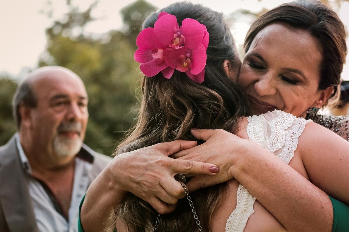 mãe abraça emocionada a noiva filha em casamento lindo no pôr do sol no hotel fazenda sete lagos em Guaratinguetá fotos erasmo ballot
