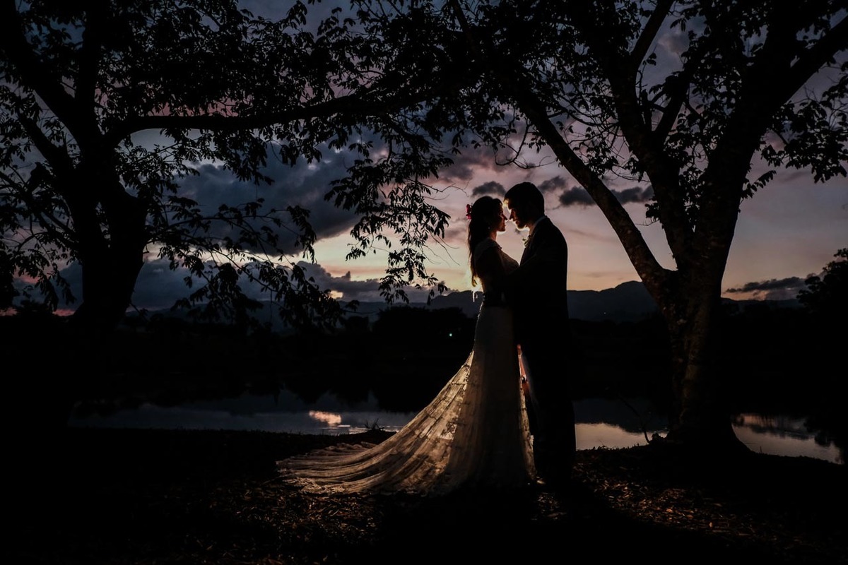 fotos posadas com casal em primeiro momento juntos casados no pôr do sol parecendo pintura com arvores luz e sombra artistica em casamento lindo no pôr do sol no hotel fazenda sete lagos em Guaratinguetá fotos erasmo ballot