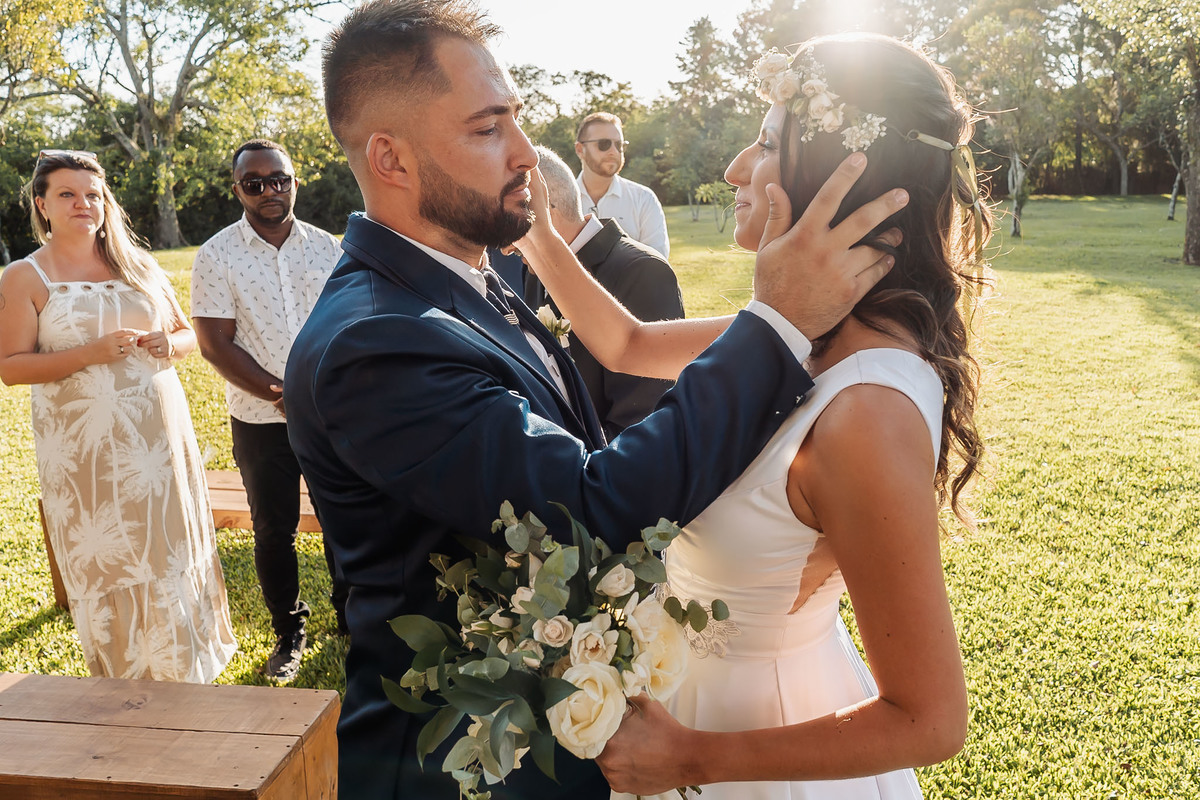 Cena espontânea de casamento intimista na Alameda da Figueira, em Cachoeirinha/RS, com foco na emoção e nos detalhes do evento.